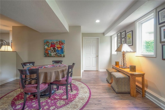 dining area with baseboards, wood finished floors, and recessed lighting