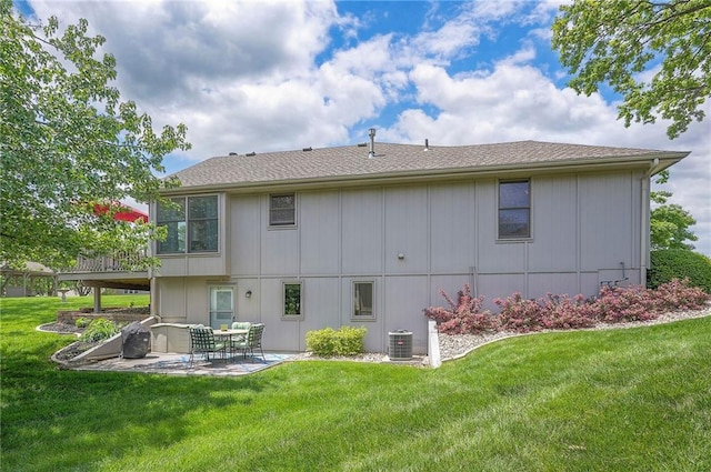 back of house featuring central AC unit, a patio area, a yard, and roof with shingles
