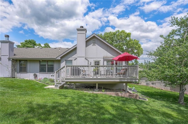 back of house with a chimney, a wooden deck, and a yard