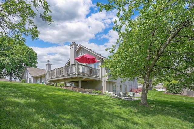 rear view of property with a wooden deck and a yard