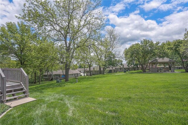 view of green lawn with a gazebo, a deck, and a residential view