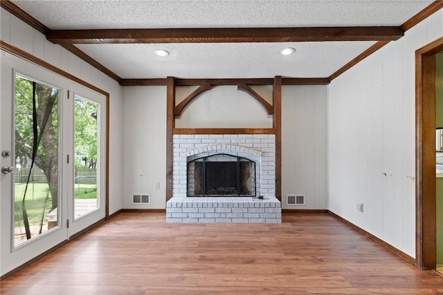 515 London Way, Belton, MO 64012 - unfurnished living room with beam ceiling, wood finished floors, crown molding, plenty of natural light, and a brick fireplace