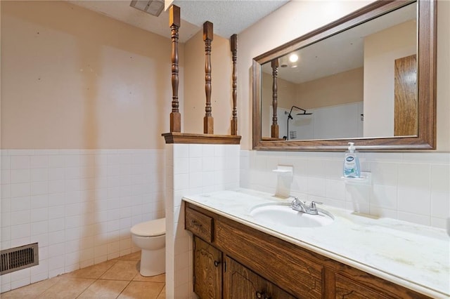 515 London Way, Belton, MO 64012 - full bathroom featuring toilet, vanity, tile walls, wainscoting, and tile patterned floors