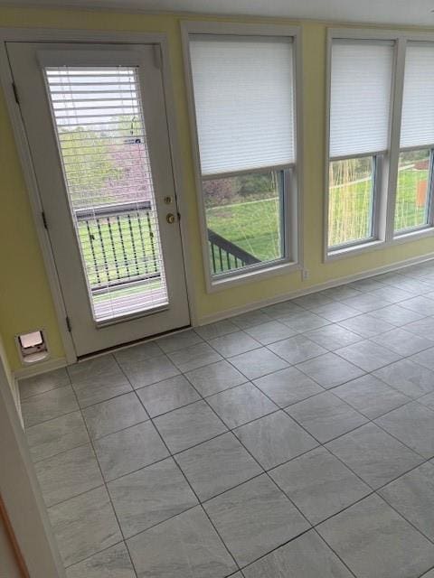 doorway to outside featuring light tile patterned floors, baseboards, and french doors