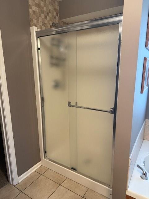 bathroom featuring a shower stall, a bath, and tile patterned floors