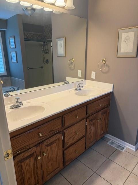 bathroom with tile patterned floors, visible vents, and a sink