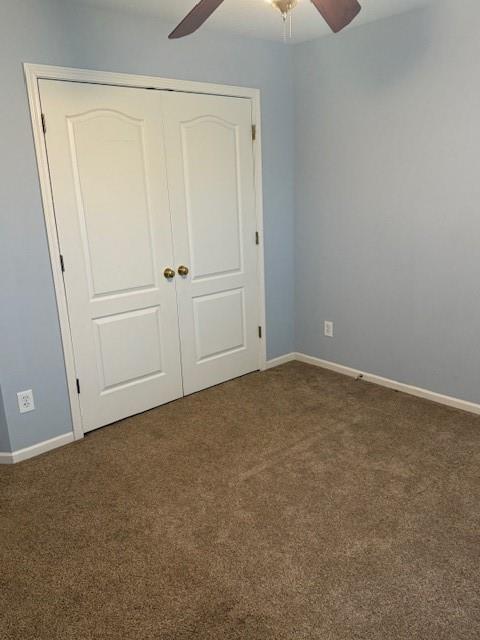 unfurnished bedroom featuring carpet, a closet, and baseboards