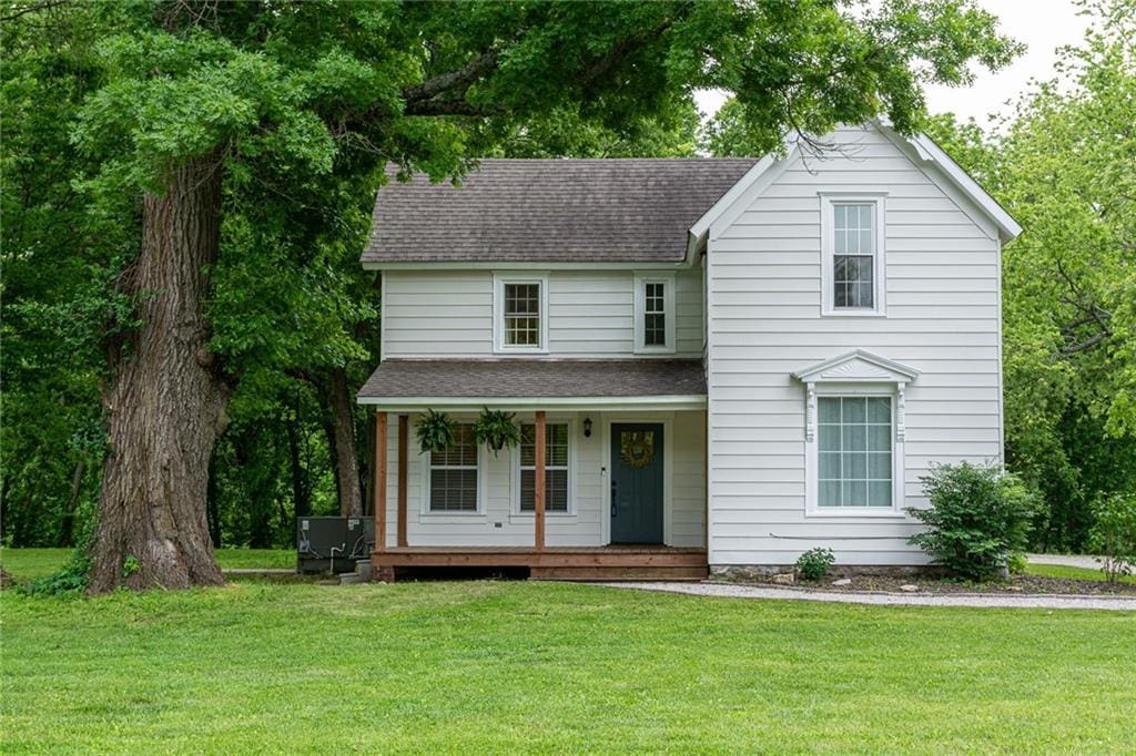 31297 Santa Fe Rd, Paola, KS 66071 - view of front of home with covered porch, roof with shingles, and a front lawn