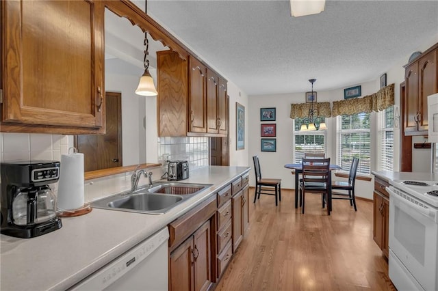 16611 E 53rd St, Independence, MO 64055 - kitchen with white appliances, a sink, brown cabinetry, light countertops, and decorative backsplash