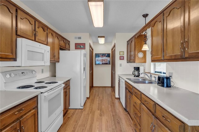 16611 E 53rd St, Independence, MO 64055 - kitchen with white appliances, a sink, light wood-style floors, and brown cabinets