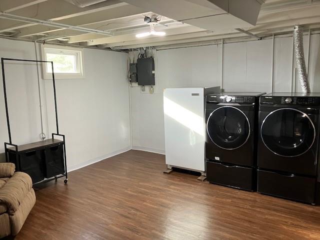 laundry area featuring electric panel, washing machine and dryer, baseboards, and dark wood-style floors