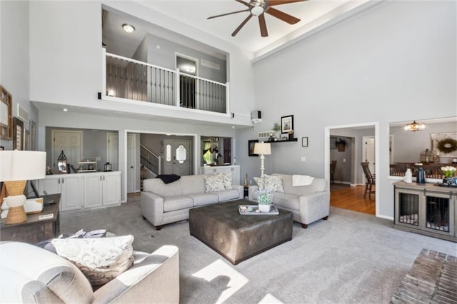 17201 NE 136th St, Kearney, MO 64060 - living area featuring light carpet, a towering ceiling, a ceiling fan, stairs, and a chandelier