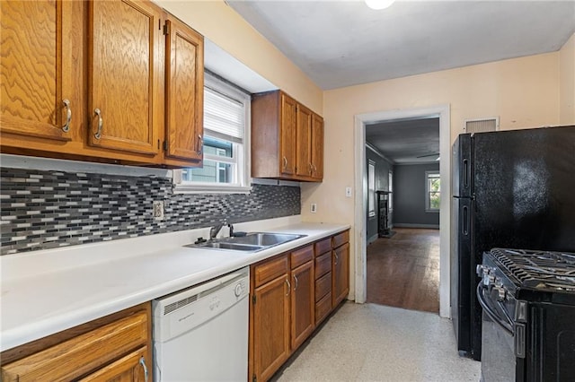 kitchen featuring dishwasher, a sink, gas stove, and tasteful backsplash