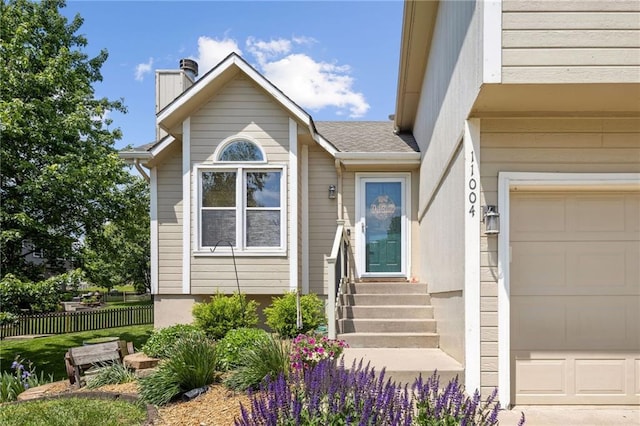 11004 N Kentucky Pl, Kansas City, MO 64157 - view of exterior entry featuring a chimney, fence, and a garage