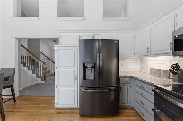 11004 N Kentucky Pl, Kansas City, MO 64157 - kitchen featuring stainless steel appliances, gray cabinetry, white cabinets, tasteful backsplash, and light wood-type flooring