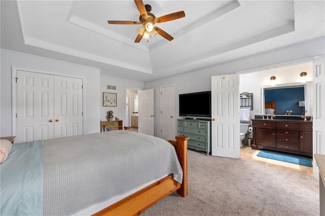 11004 N Kentucky Pl, Kansas City, MO 64157 - bedroom with a tray ceiling, light carpet, ensuite bathroom, a ceiling fan, and a sink