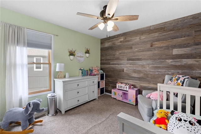 11004 N Kentucky Pl, Kansas City, MO 64157 - bedroom with wood walls, carpet flooring, a ceiling fan, and a crib
