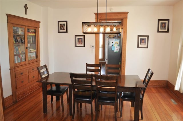 dining space with baseboards and hardwood / wood-style floors