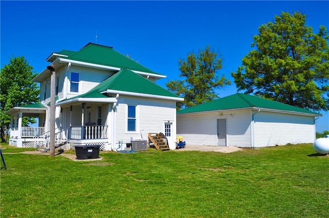 back of property featuring a porch, metal roof, and a yard