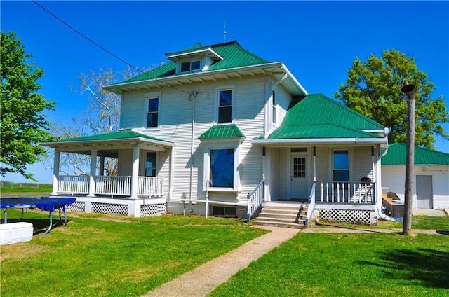view of front of property with a porch, metal roof, and a front yard