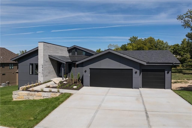 view of front of home featuring a garage, concrete driveway, and a front yard