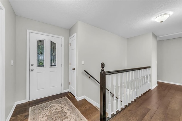 entrance foyer featuring wood finished floors, a textured ceiling, and baseboards