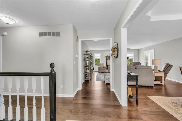 entrance foyer with dark wood finished floors, baseboards, and a textured ceiling