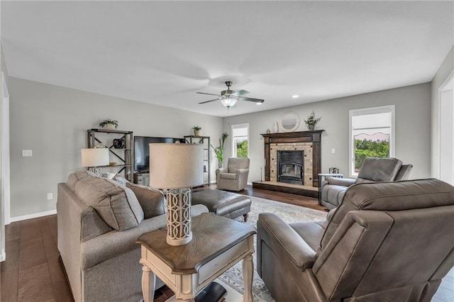 living area featuring dark wood finished floors, a ceiling fan, a stone fireplace, baseboards, and recessed lighting