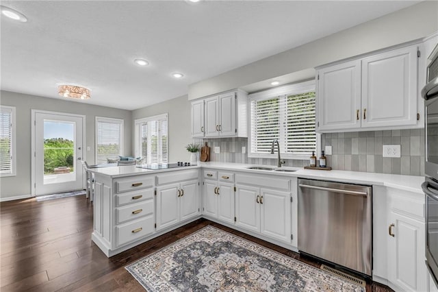 kitchen featuring dishwasher, a sink, a peninsula, plenty of natural light, and recessed lighting
