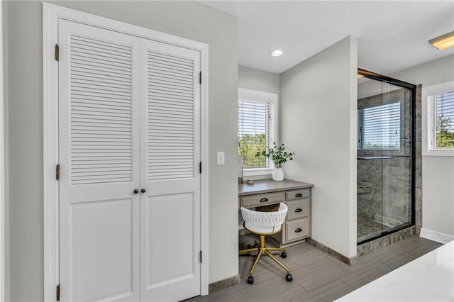 bathroom with baseboards, a stall shower, recessed lighting, and a closet