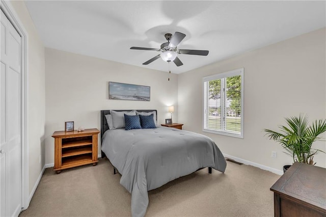 bedroom featuring baseboards, light carpet, and ceiling fan