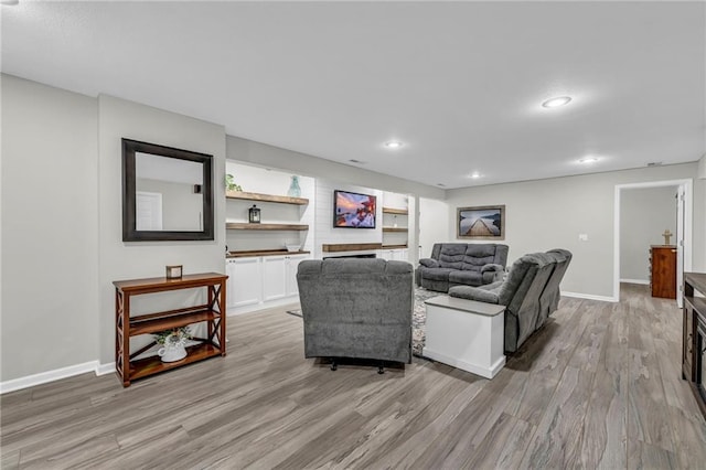living area featuring light wood-style flooring, baseboards, and recessed lighting
