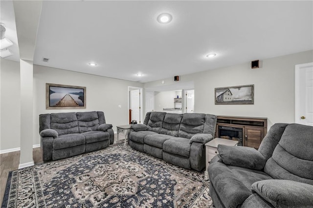 living room featuring wood finished floors, recessed lighting, and baseboards