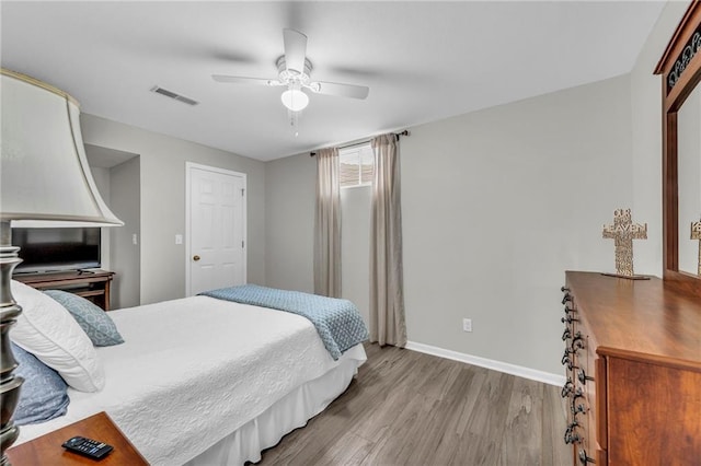 bedroom with wood finished floors, baseboards, and a ceiling fan
