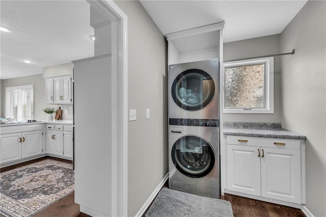 laundry room with stacked washer and clothes dryer, dark wood-style floors, and recessed lighting