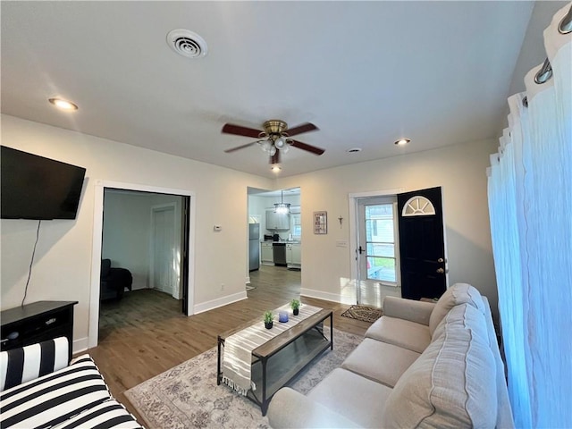 living area with a ceiling fan, recessed lighting, baseboards, visible vents, and wood finished floors