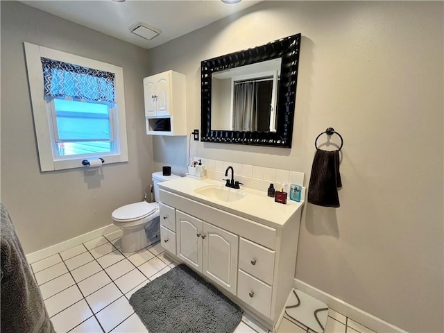 bathroom featuring tile patterned floors, toilet, baseboards, and vanity