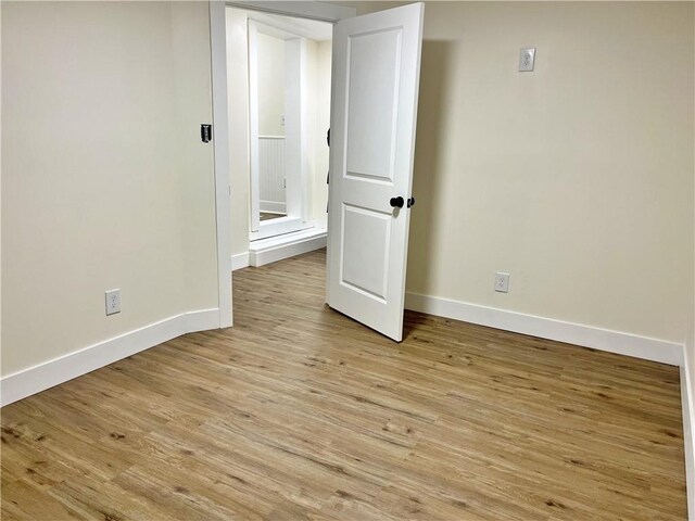 unfurnished room with light wood-style floors and baseboards