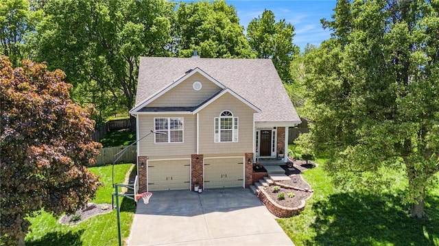 view of front of house featuring driveway, brick siding, fence, a garage, and a front lawn