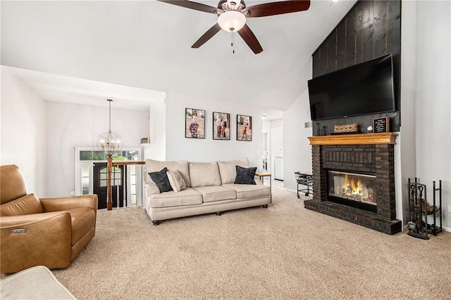 living area with carpet, ceiling fan with notable chandelier, a brick fireplace, and high vaulted ceiling