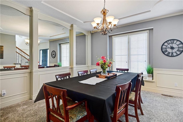 8904 NE 94th Pl, Kansas City, MO 64157 - carpeted dining area with a decorative wall, a wainscoted wall, a chandelier, healthy amount of natural light, and stairway