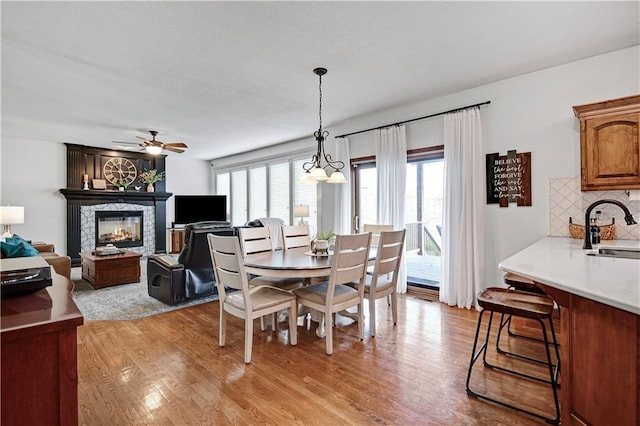 8904 NE 94th Pl, Kansas City, MO 64157 - dining area featuring a multi sided fireplace, light wood-type flooring, and a ceiling fan