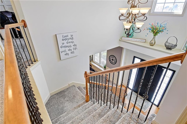 8904 NE 94th Pl, Kansas City, MO 64157 - stairway with a chandelier, healthy amount of natural light, a towering ceiling, and baseboards