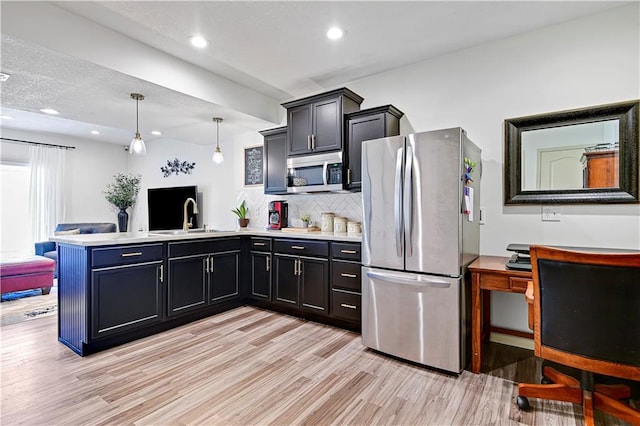 8904 NE 94th Pl, Kansas City, MO 64157 - kitchen with stainless steel appliances, a peninsula, light wood-style floors, tasteful backsplash, and light countertops