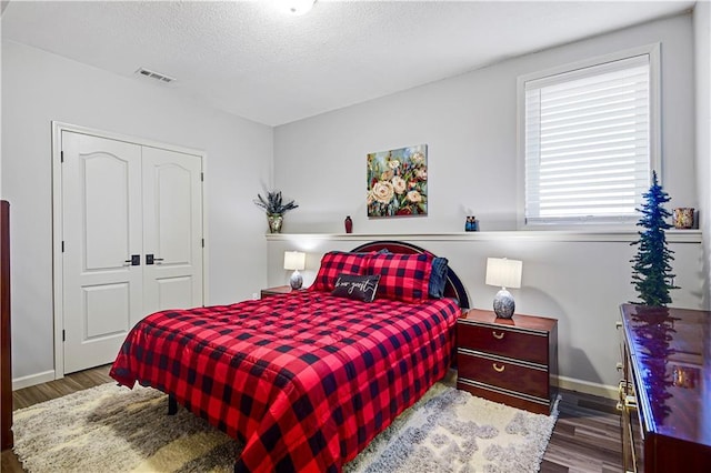 8904 NE 94th Pl, Kansas City, MO 64157 - bedroom featuring wood finished floors, a closet, baseboards, and a textured ceiling