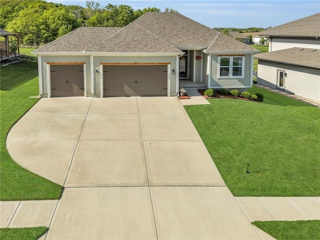 view of front facade featuring an attached garage, driveway, a front yard, a shingled roof, and stucco siding