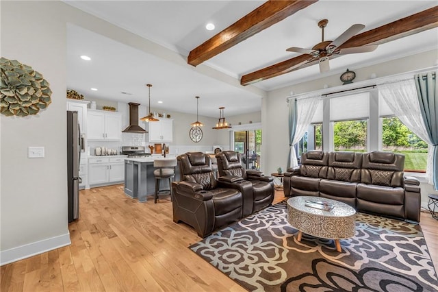 living area featuring a ceiling fan, beamed ceiling, light wood finished floors, recessed lighting, and crown molding
