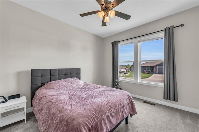 carpeted bedroom featuring baseboards and a ceiling fan