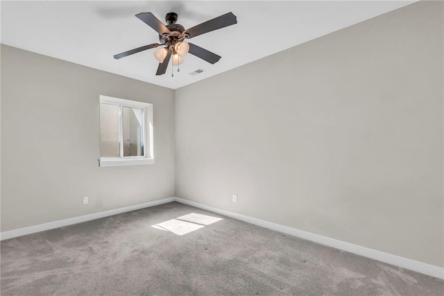 carpeted spare room featuring baseboards and ceiling fan