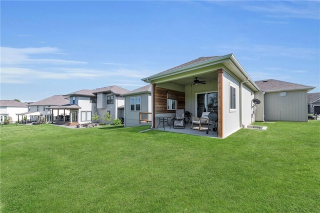 rear view of property featuring ceiling fan, a patio area, a yard, and a gazebo